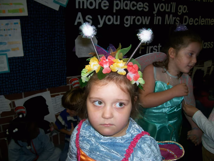 Hannah Kakish as a child, dressed as a flower fairy in a classroom